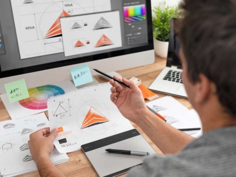 Designer working on a logo and website layout at a desk